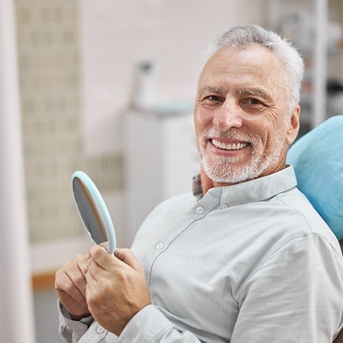 senior man smiling in dental chair 