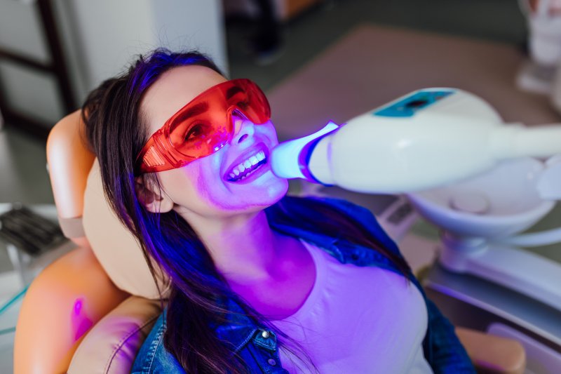 A smiling woman getting her teeth professionally whitened